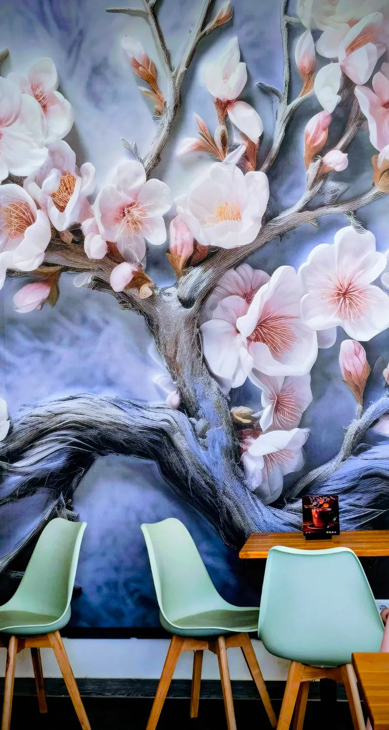 Kirschblüten-Wandbild im Gastraum mit mintgrünen Stühlen